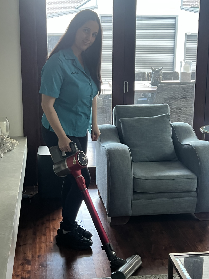 A NutureNest support worker vacuuming a living room during a domestic and cleaning assistance visit in South West Sydney