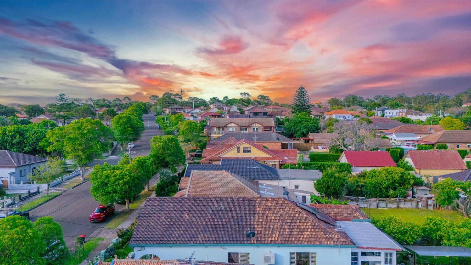 Aerial view at sunset over South West Sydney suburban rooftops and leafy streets near Revesby, Padstow, Panania and Bankstown